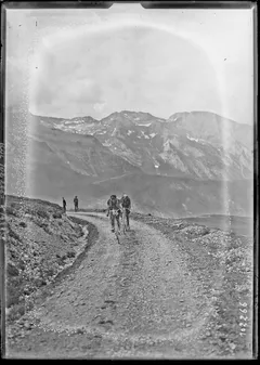 Cyklisté tlačí kola štěrkovým stoupáním na Aubisque, Tour de France 1925