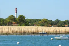 Maják Cap Ferret nad ústřicovými lůžky v Arcachonském zálivu