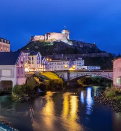 Château fort de Lourdes se zrcadlí v klidné hladině řeky Gave de Pau