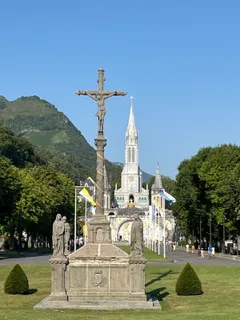 Bazilika z esplanády za jasného dne, věž se tyčí do modré oblohy