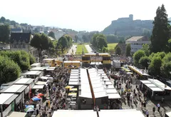 Zázemí Tour de France 2018 na esplanádě v Lourdes, hradní pevnost shlíží z kopce